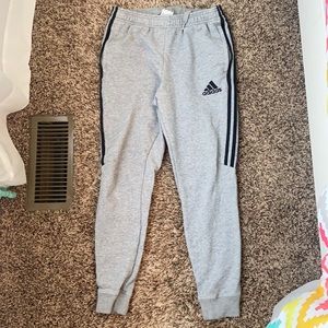Grey Adidas pants with black stripes down side. Size small.